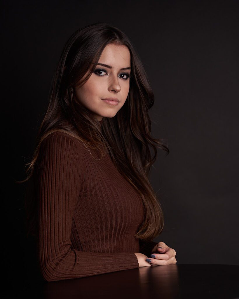 Joven mujer de cabello largo castaño y blusa de cuello de tortuga